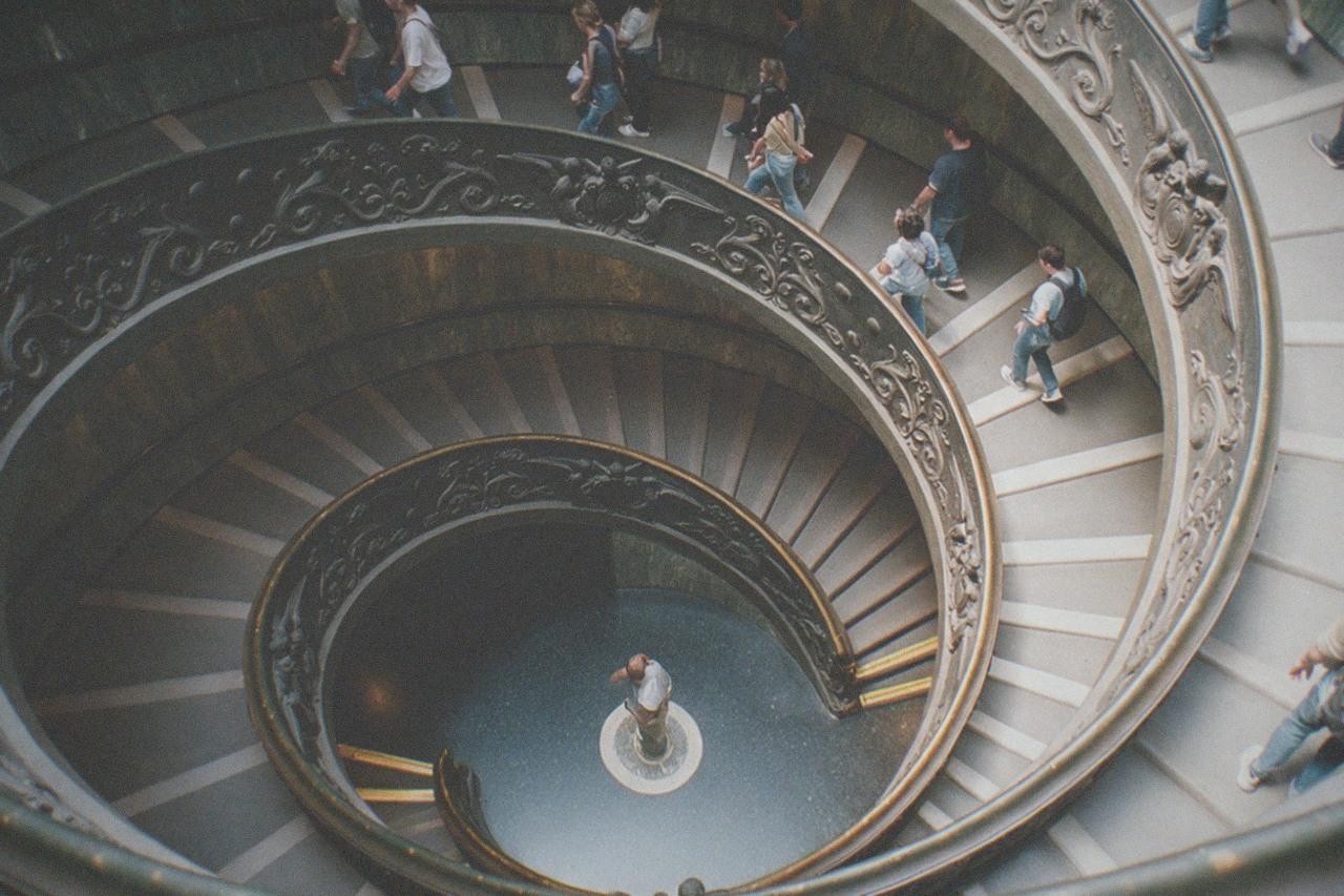 The spiral staircase of the Vatican Museums seen from above, a crowd of visitors walking down