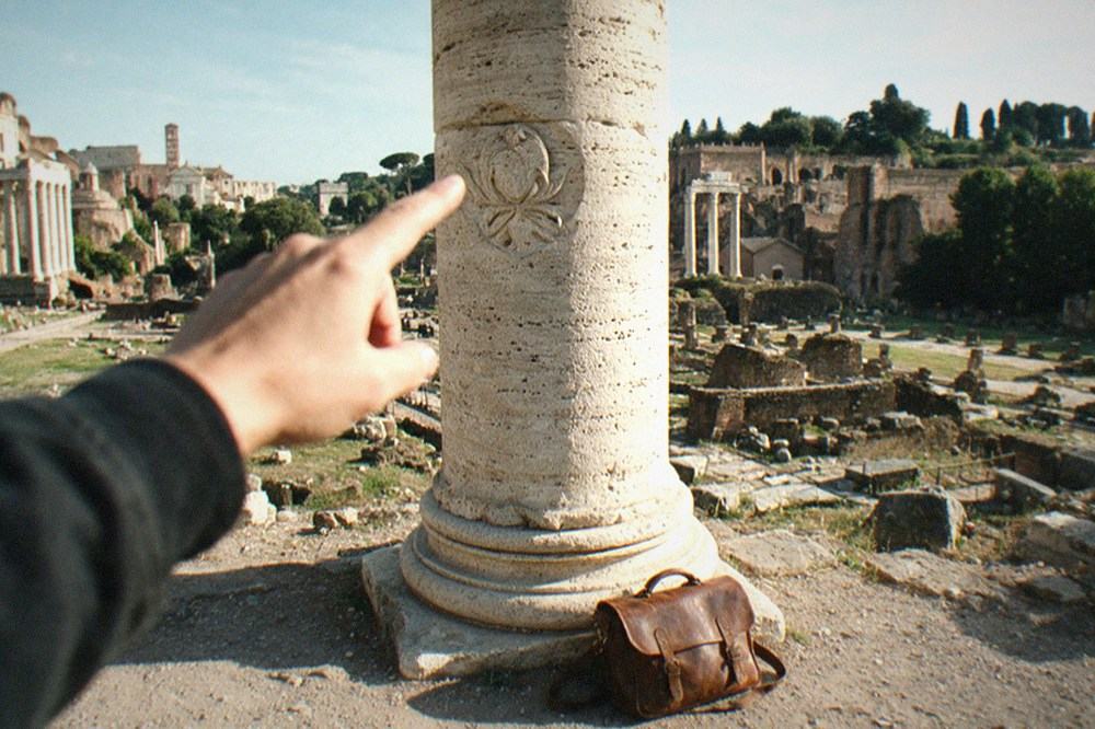 A carved detail on a weathered travertine column in the Roman Forum in sharp morning light