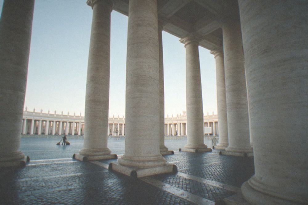 The colonnade columns of St Peter's Square framing an early morning sky