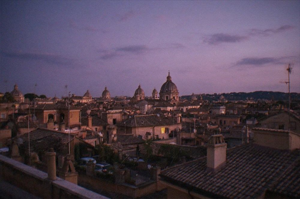 Rome rooftops and dome silhouettes at dusk seen from a high terrace
