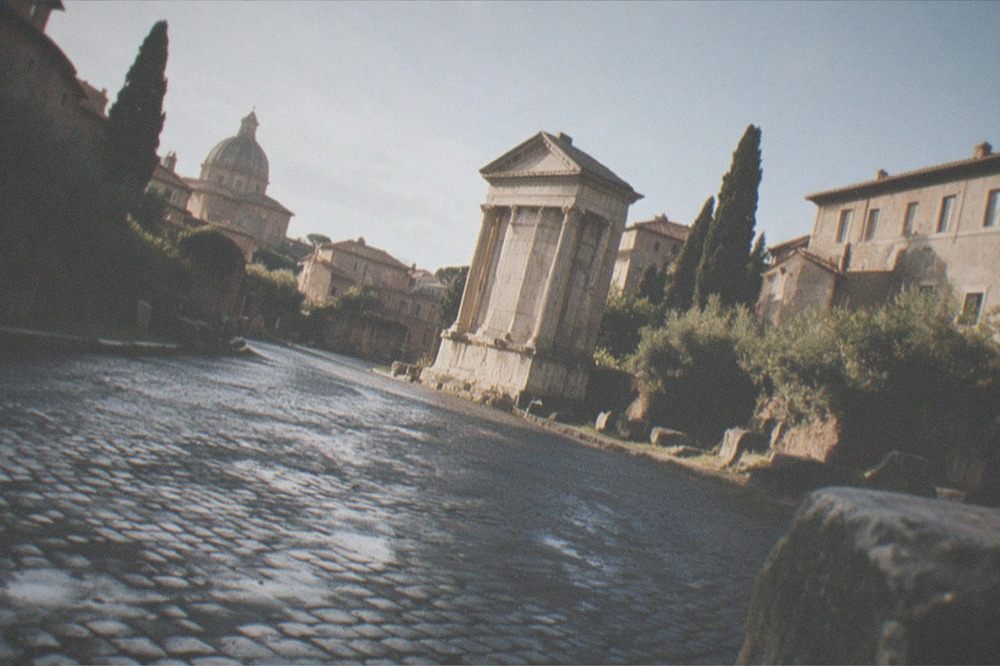 A quiet cobbled Rome street still damp from overnight rain