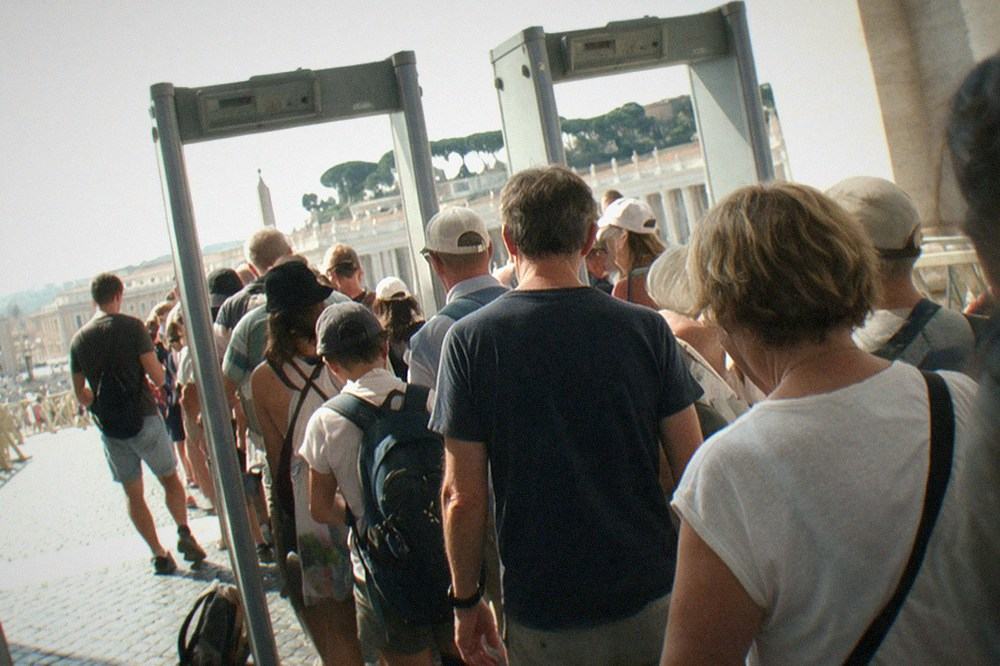 Queue of visitors passing through airport-style security scanners in St Peter's Square