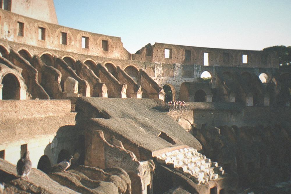 A wide view of the Colosseum stands and arches in afternoon light