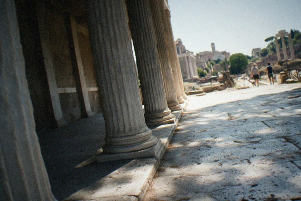 Shaded colonnade columns and worn stone pavement inside the ancient site