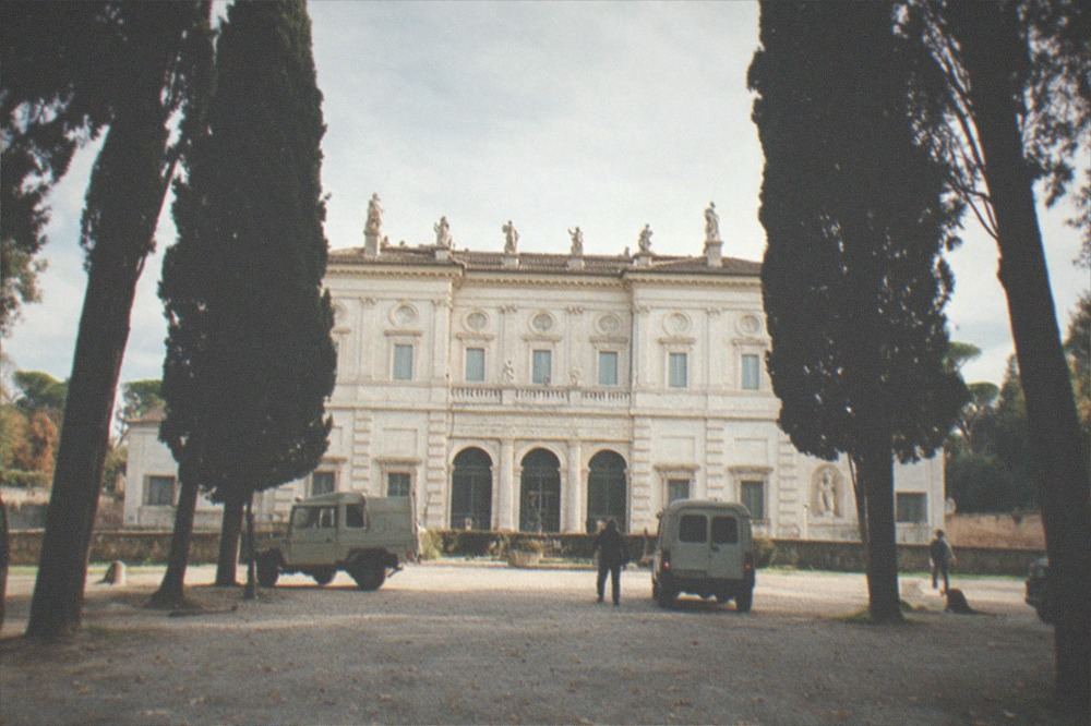 Classical facade of the Galleria Borghese behind cypress trees