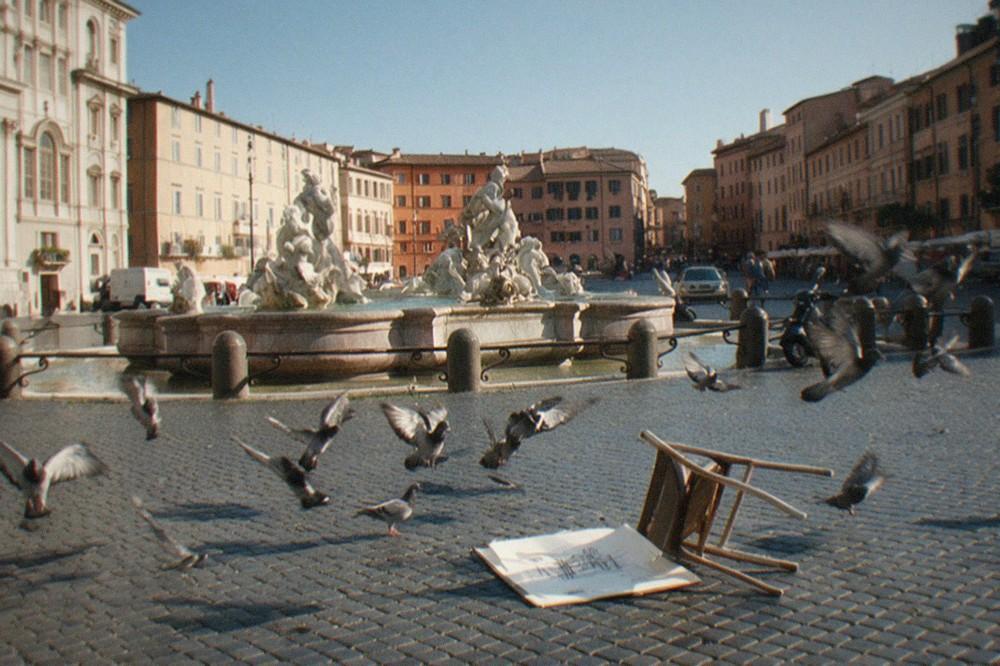 A sunlit Roman piazza with baroque facades and an old fountain against a clear sky